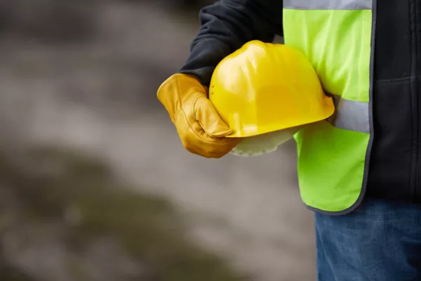  A worker holding a safety helmet highlighting the need for construction lifting equipment. 