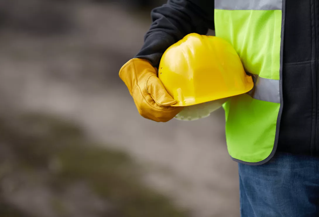  A worker holding a safety helmet highlighting the need for construction lifting equipment. 